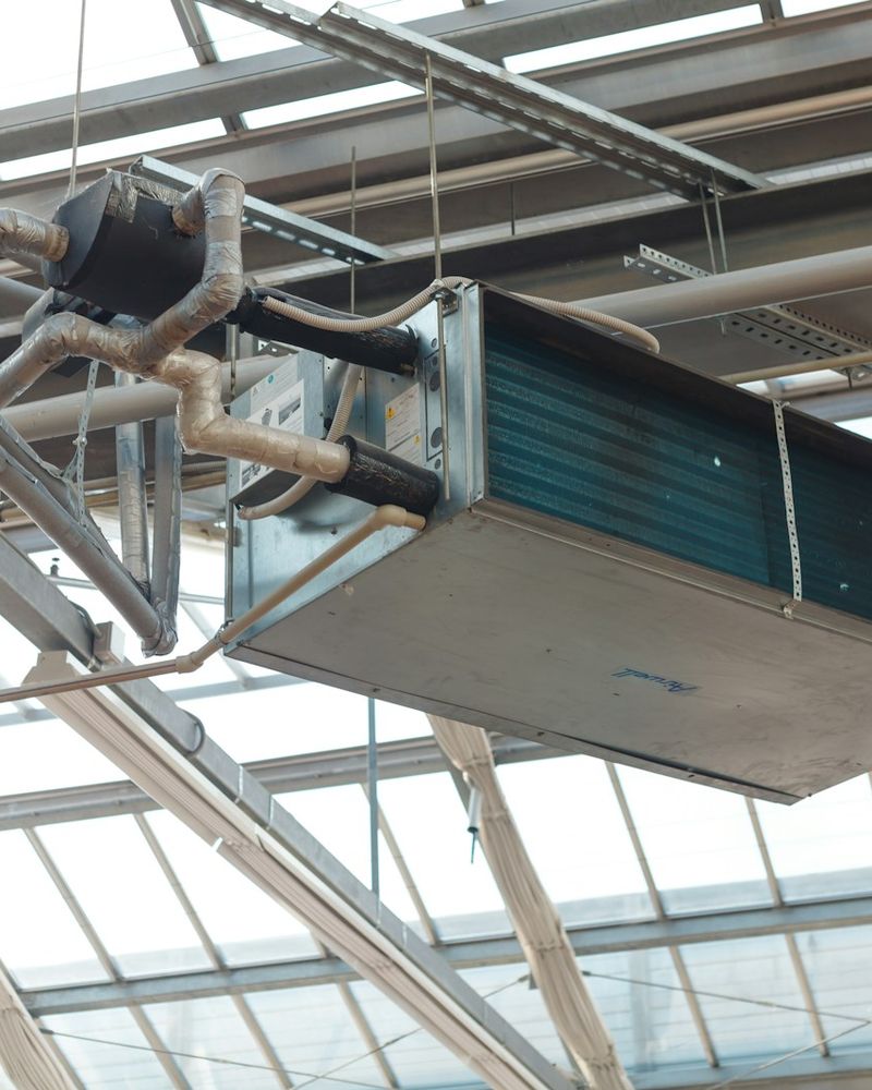 Unidad de ventilación suspendida con ductos en una estructura metálica
