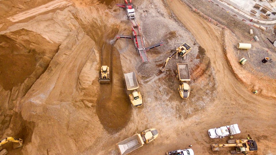 Vista aérea con dron de un movimiento de tierras con volquetes y maquinaria